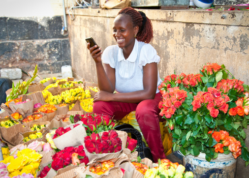 Nairobi, Kenya  - February 5, 2014:  Unidentified black woman sells flowers at old market in centre of Nairobi on February 9, 2014.  Africa.