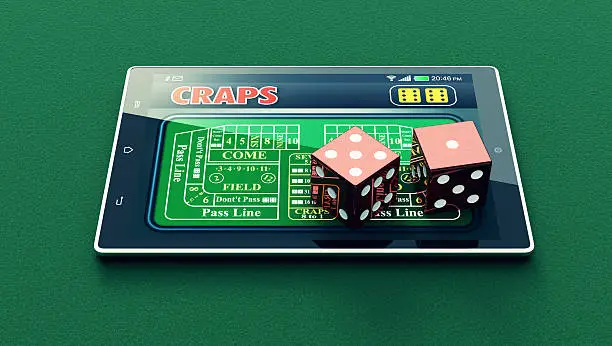 tablet pc with a craps app and a couple of dice on green background (3d render)