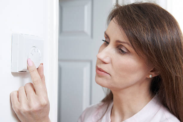 istock Woman Adjusting Thermostat On Central Heating Control 507688601