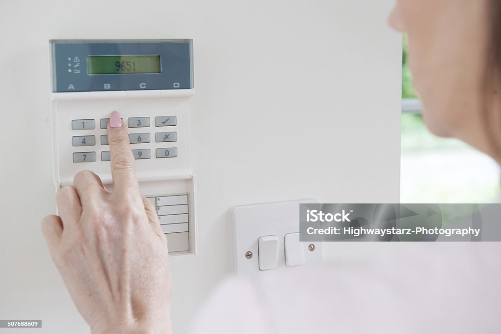 Woman Setting Control Panel On Home Security System Burglar Alarm Stock Photo