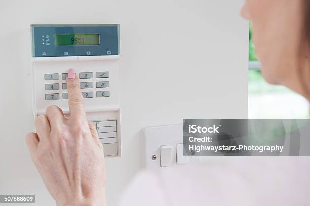 Woman Setting Control Panel On Home Security System Stock Photo - Download Image Now