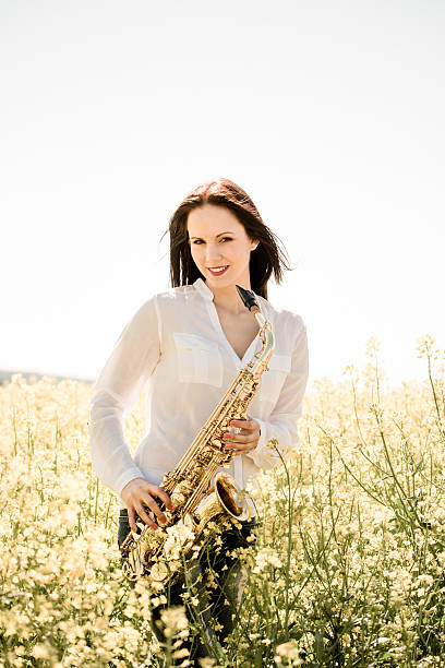 istock Woman with saxophone in rapeseed field 507688934