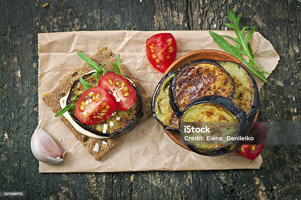 Vegetarian Diet Crispbread sandwiches Vegetarian Diet Crispbread sandwiches with garlic cream cheese, roasted eggplant, arugula and cherry tomatoes on old wooden background Appetizer Stock Photo