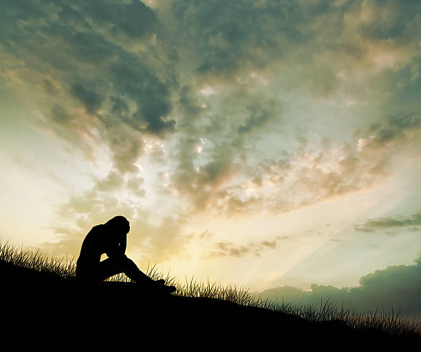 istock woman depression sitting on meadow 507706890