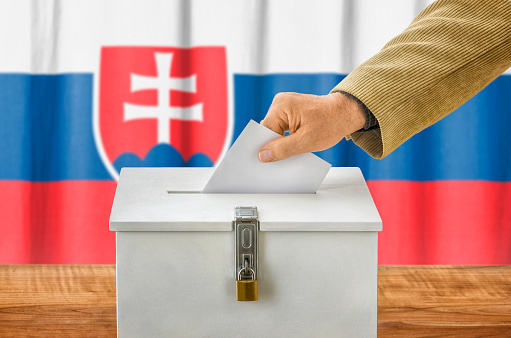 Hombre poniendo un papeleta de voto en una caja de Eslovaquia photo