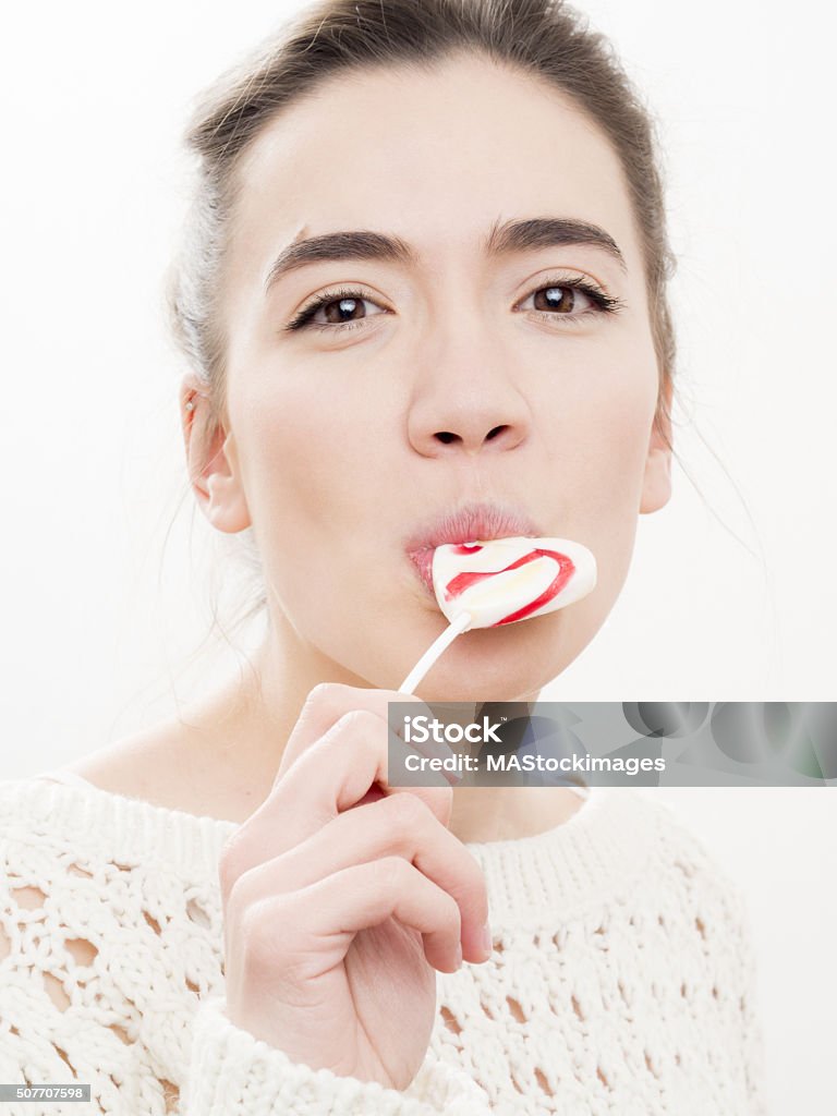 vertical de una mujer joven con caramelo de paleta - Foto de stock de Adulto libre de derechos