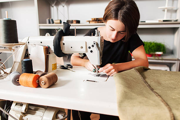 costurera poner rosca aguja. disfrutar en el lugar de trabajo - embroidery textile industry clothing factory fotografías e imágenes de stock