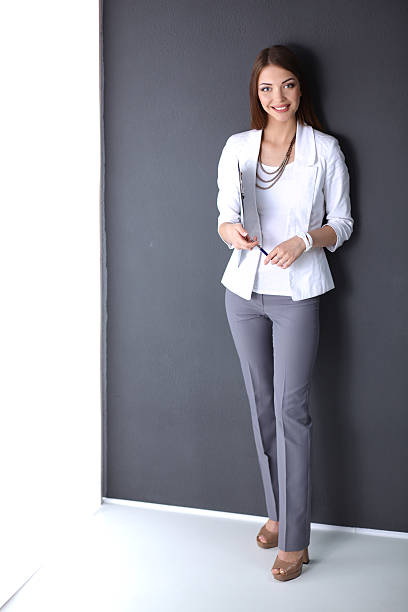 istock Young woman holding a laptop, standing on gray background 507708880