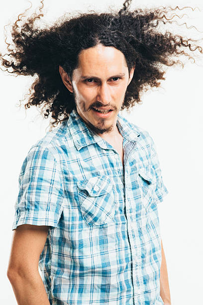 mixed race man with curly long hair outdoors ar sunny day.