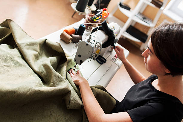 couturière coud vêtements. lieu de travail de tailleur - machine sewing white sewing item photos et images de collection