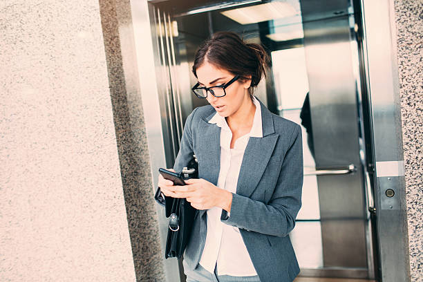 istock Businesswoman Texting  In The Elevator 507710120