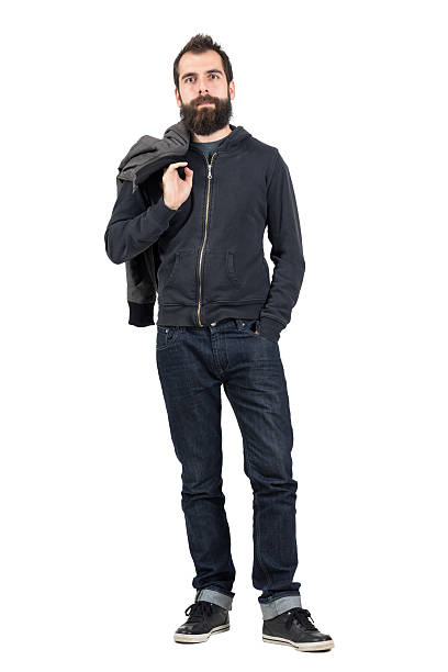 istock Serious hipster in hooded sweatshirt carrying jacket looking at camera 507710340