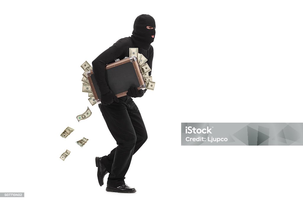 Burglar running with a bag full of money Studio shot of a male burglar with a mask on his head running with a briefcase full of money isolated on white background Thief Stock Photo