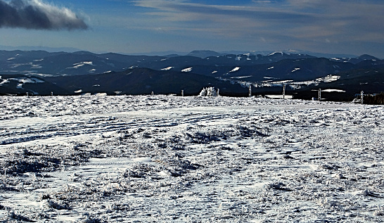 panorama of winter mountains during snowshoeing on Fischbacher Alpen in Styria with blue sky and only few clouds