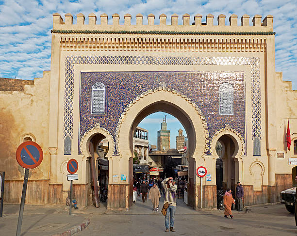 Bab Bou Jeloud. Fez El Bali Medina. Fez, Morocco. Africa. Fez, Morocco - December 14, 2015: Tourist taking photos and people with djellaba walking in Bab Bou Jeloud. The blue gate is a gate to ancient Fez El Bali Medina. bab boujeloud stock pictures, royalty-free photos & images