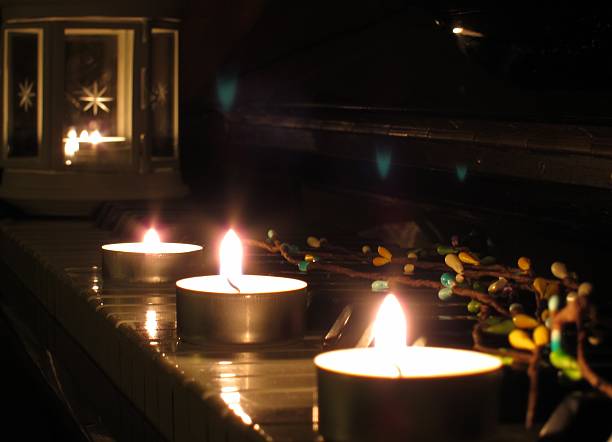 istock Three lighted candles and tree blossom branch on the piano 507720216