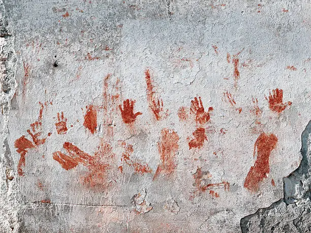 Photo of Bloody hands painted on old wall