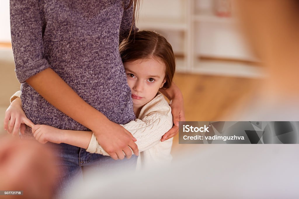 Quarrels between parents Child hugs her mother and protects her from evil father during an argument at home Divorce Stock Photo