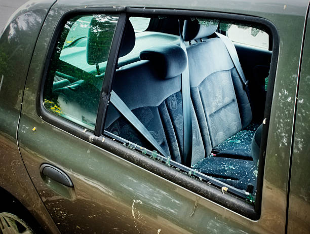 Car break-in A parked car which has been broken into, leaving smashed glass all over the rear seats. back seat photos stock pictures, royalty-free photos & images