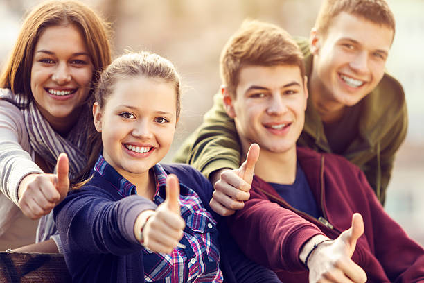 group of happy подростковой друзей, показывая пальцем вверх - thumbs up teenager adolescence group of people стоковые фото и изображения