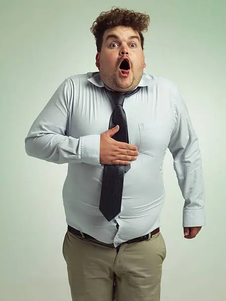 Shot of an overweight man holding his chest