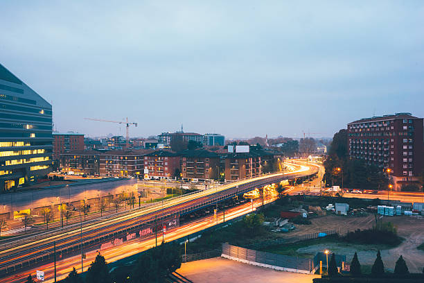 vue de nuit de la ville avec une longue exposition coloré de - traffic blurred motion multiple lane highway night photos et images de collection