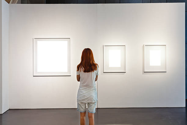 una mujer mirando a cuadros blanco en una galería de arte - mirar un objeto fotos fotografías e imágenes de stock