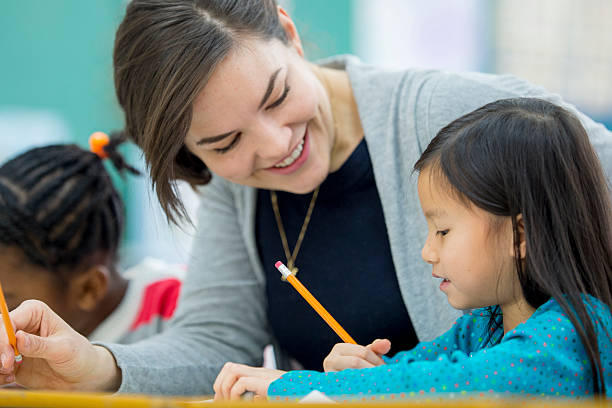 istock Little Girl Getting Help from Her Teacher 507749680