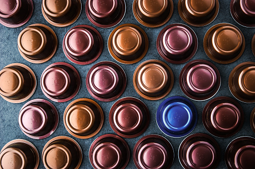 Coffee capsules on the dark stone table top view horizontal