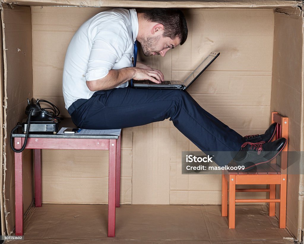 Homme d'affaires dans une étrange position - Photo de Trop petit libre de droits