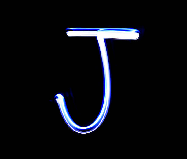 istock J Jimmy alphabet hand writing blue light  over black background. 507752310