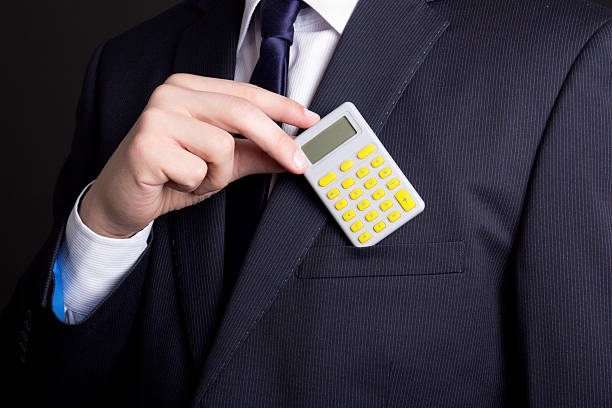 istock man in business suit putting calculator into pocket 507752636