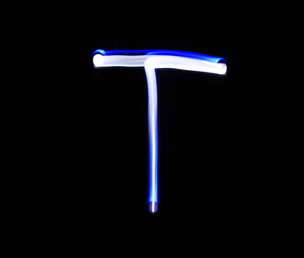 istock T Tango alphabet hand writing blue light  over black background. 507752810