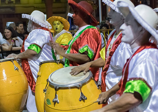 Montevideo, Uruguay - January 22, 2016:  Costumed men drummers playing traditional music called candombe at the inaugural parade of carnival of Montevideo, Uruguay