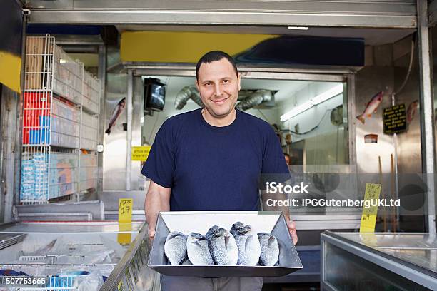 Owner Displaying Fresh Fish In Store Stock Photo - Download Image Now - Front View, Seafood, Adult