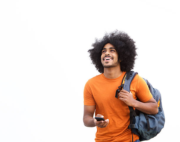 Happy guy walking with mobile phone and bag Portrait of a happy guy walking with mobile phone and bag men hairstyle afro cool stock pictures, royalty-free photos & images
