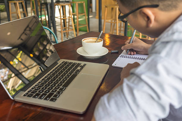istock Asian businessman writing important information into his notebook 507756668