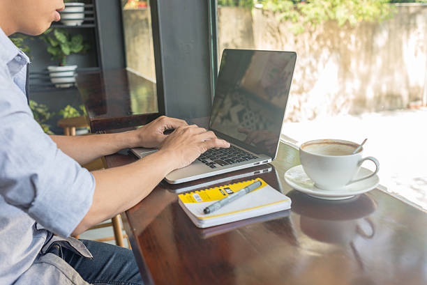 istock Typing on laptop with an empty cup of coffee beside 507757082