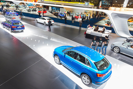 Brussels, Belgium - Januari 12, 2016: Audi motor show stand seen from above with an Audi Q3 compact SUV, Audi A4 Avant, Audi A5 Sportback and Audi A5 Cabriolet. The cars are on display during the 2016 Brussels Motor Show. There are people looking around and other cars on display in the background.