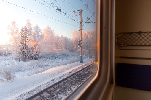 Rosa salida del sol en el bosque de invierno a través de la ventana del tren photo