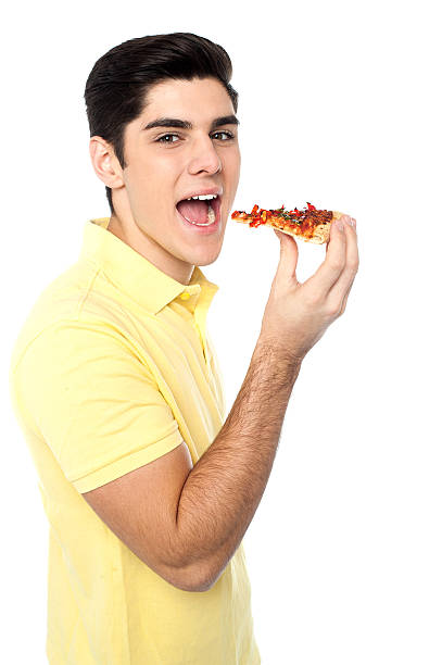 istock Young guy with a slice of pizza in hand 507769489