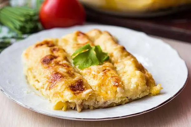 Italian pasta Cannelloni stuffed with meat, white Bechamel sauce, cheese crust, delicious dinner