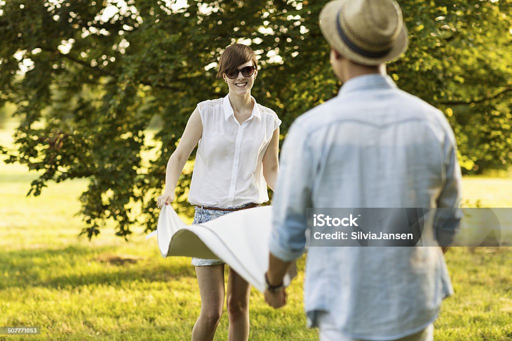 young man and woman folding blanket outdoors summer young woman and young man, folding blanket, outdoors in summer 18-19 Years Stock Photo