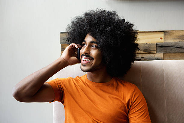 istock Happy black guy talking on mobile phone indoors 507787894