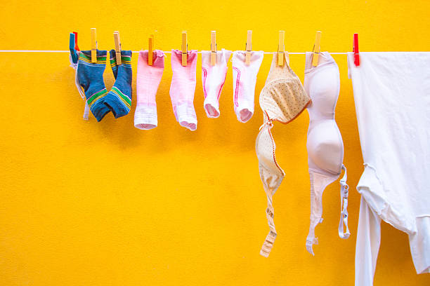 service de blanchisserie (chaussettes, brassières, chemise), en ligne et de jaune flamboyant mur, italie - bra lingerie clothesline underwear photos et images de collection
