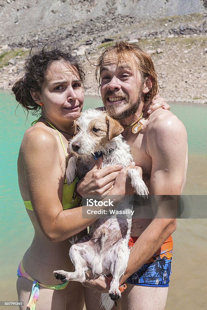 Happy couple swims in the lake with a small dog Activity Stock Photo
