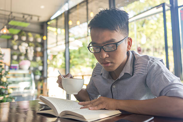istock Asian man drinking coffee and reading book 507791390