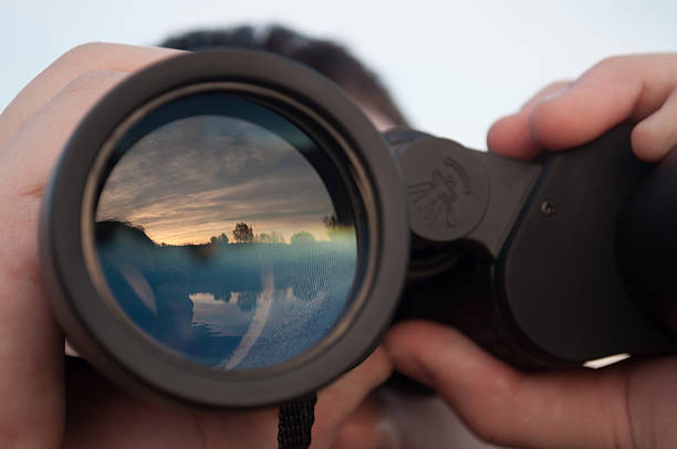 hombre mirando a través de binoculares - looking through window fotografías e imágenes de stock