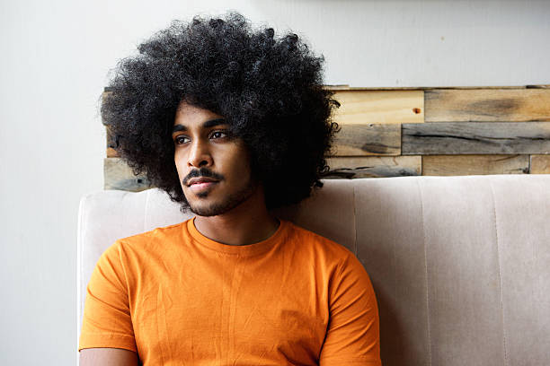 istock Young black guy with afro sitting at home thinking 507793012