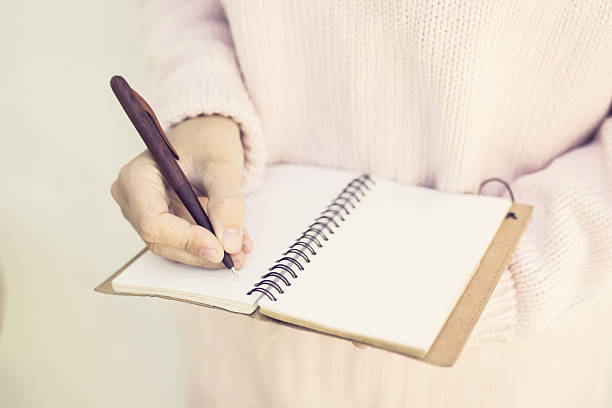 istock Girl writing with pen in blank diary 507793972